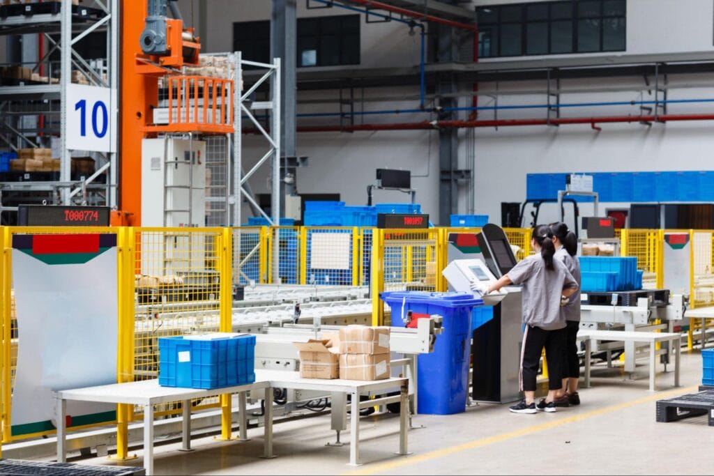 Workers managing Returnable Packaging in a modern warehouse environment.